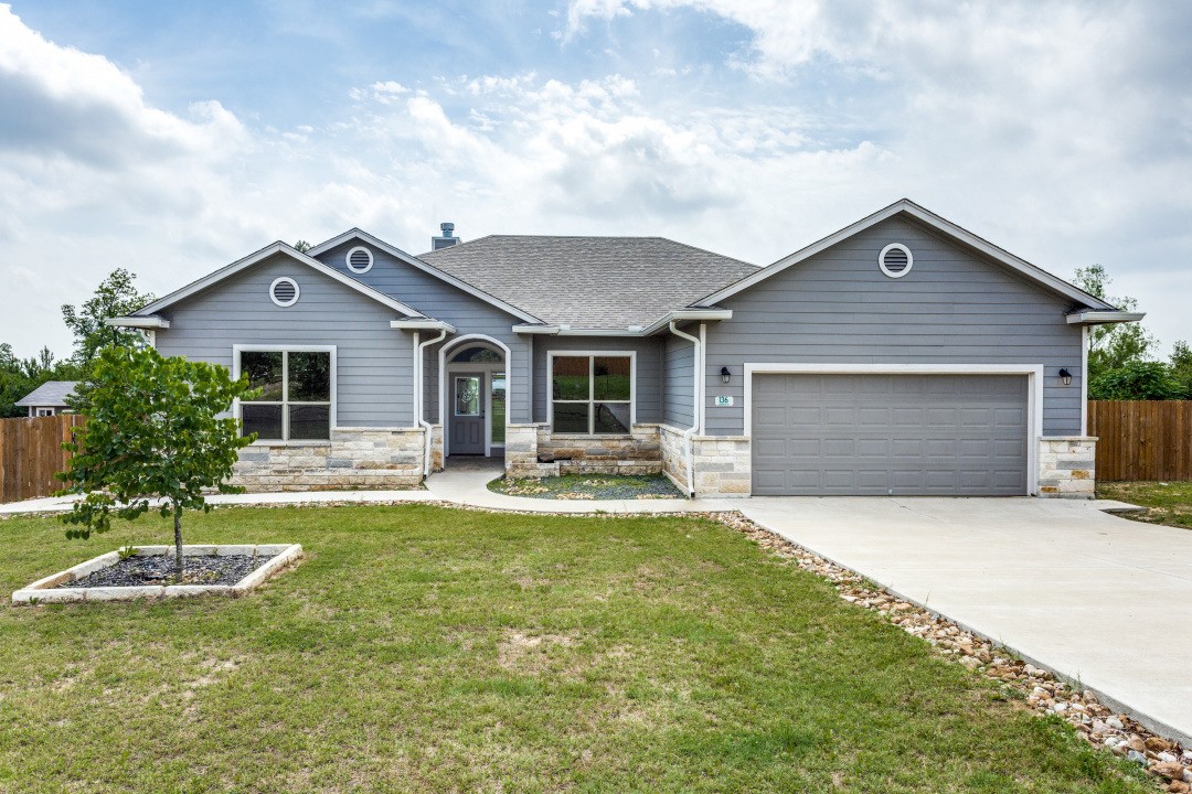 136 Comanche Drive Paige, TX 78659 - Photo 1 of 1 a front view of a house with a yard and garage