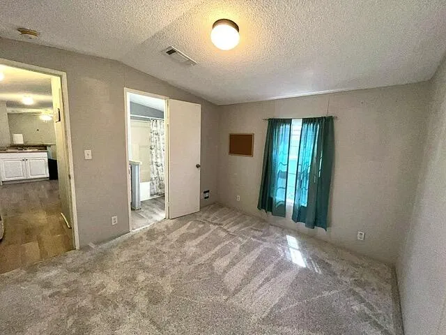 a view of an empty room with glass door and a window