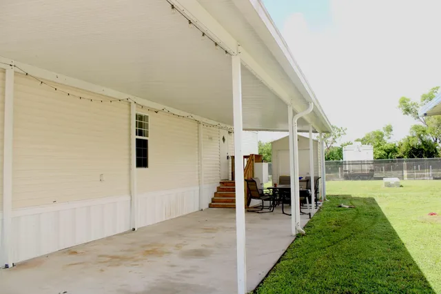 a backyard of a house with table and chairs