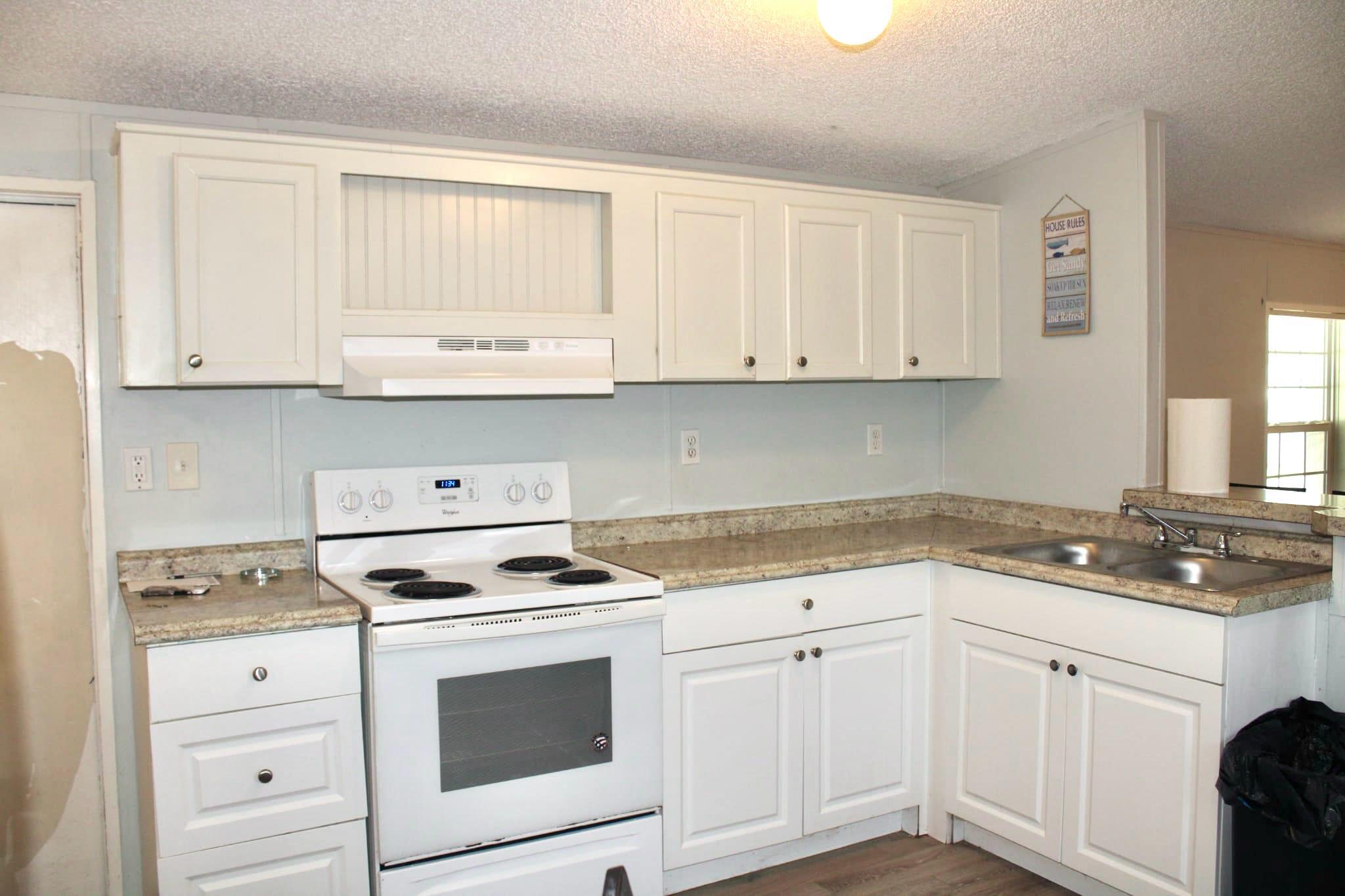 5000 Southeast Federal Highway, Unit 806 Stuart, FL 34997 - Photo 7 of 22 a kitchen with granite countertop white cabinets and white appliances