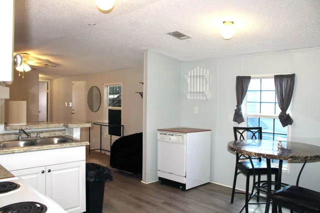 a view of a kitchen area with furniture and wooden floor
