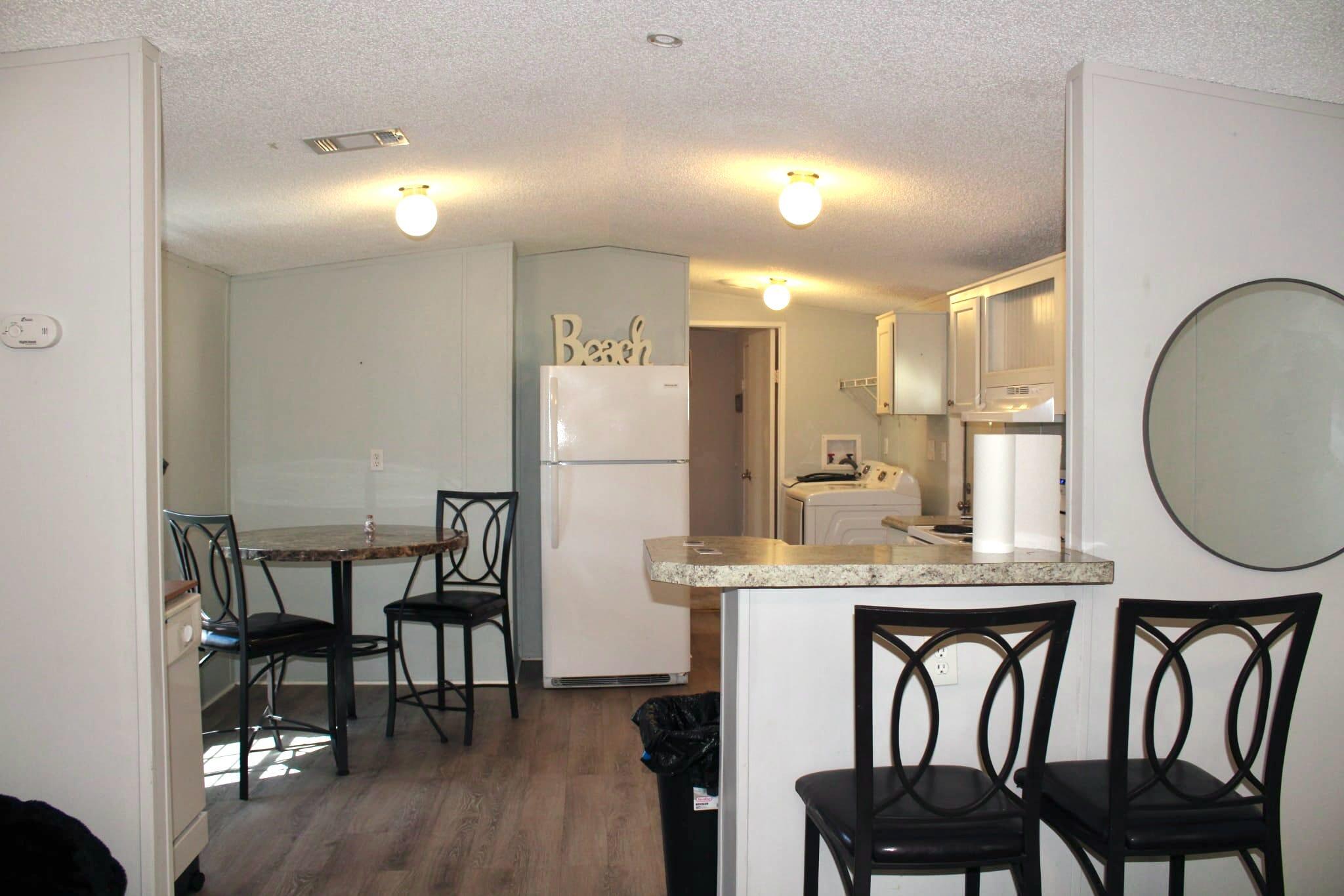 5000 Southeast Federal Highway, Unit 806 Stuart, FL 34997 - Photo 9 of 22 a kitchen with kitchen island a dining table chairs cabinets and stainless steel appliances
