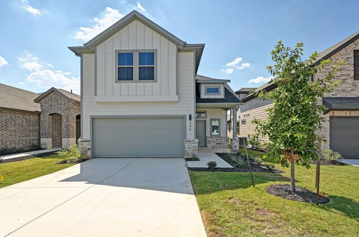 a front view of a house with a yard and garage