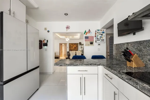 a kitchen with stainless steel appliances granite countertop a sink and a refrigerator