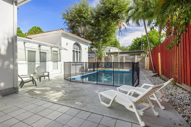 a view of a patio with table and chairs and wooden fence