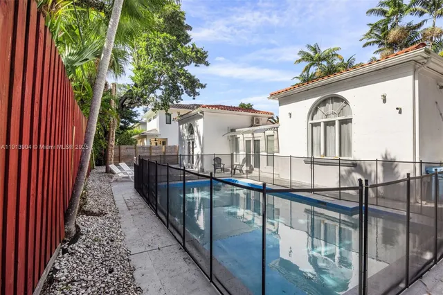 a view of a house with large windows and a small yard