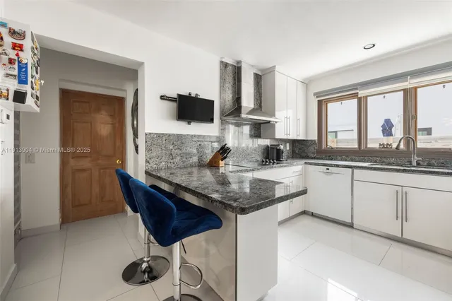 a kitchen with stainless steel appliances granite countertop a sink a stove and a refrigerator