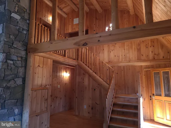 a view of an empty room with wooden floor and windows