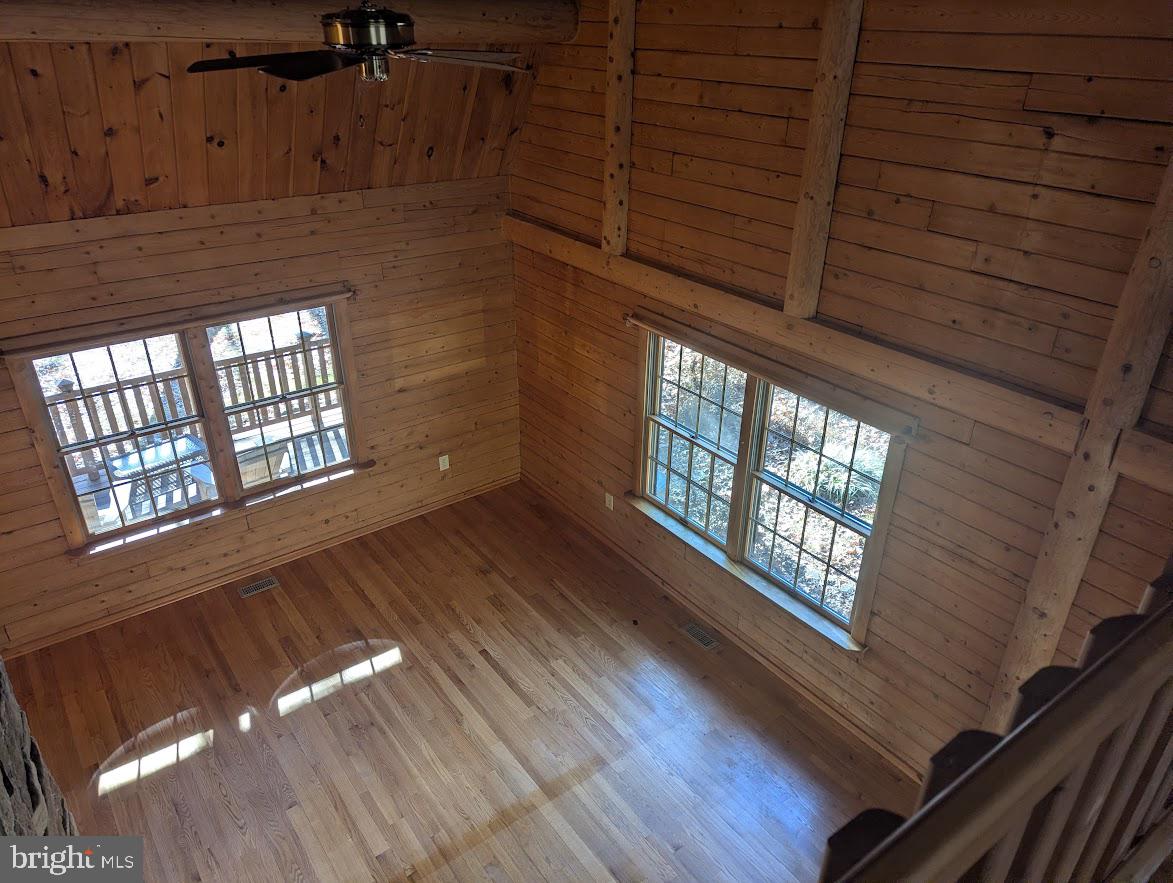 1537 Hidden Valley Road Franklin, WV 26807 - Photo 37 of 78 a view of an empty room with wooden floor and windows