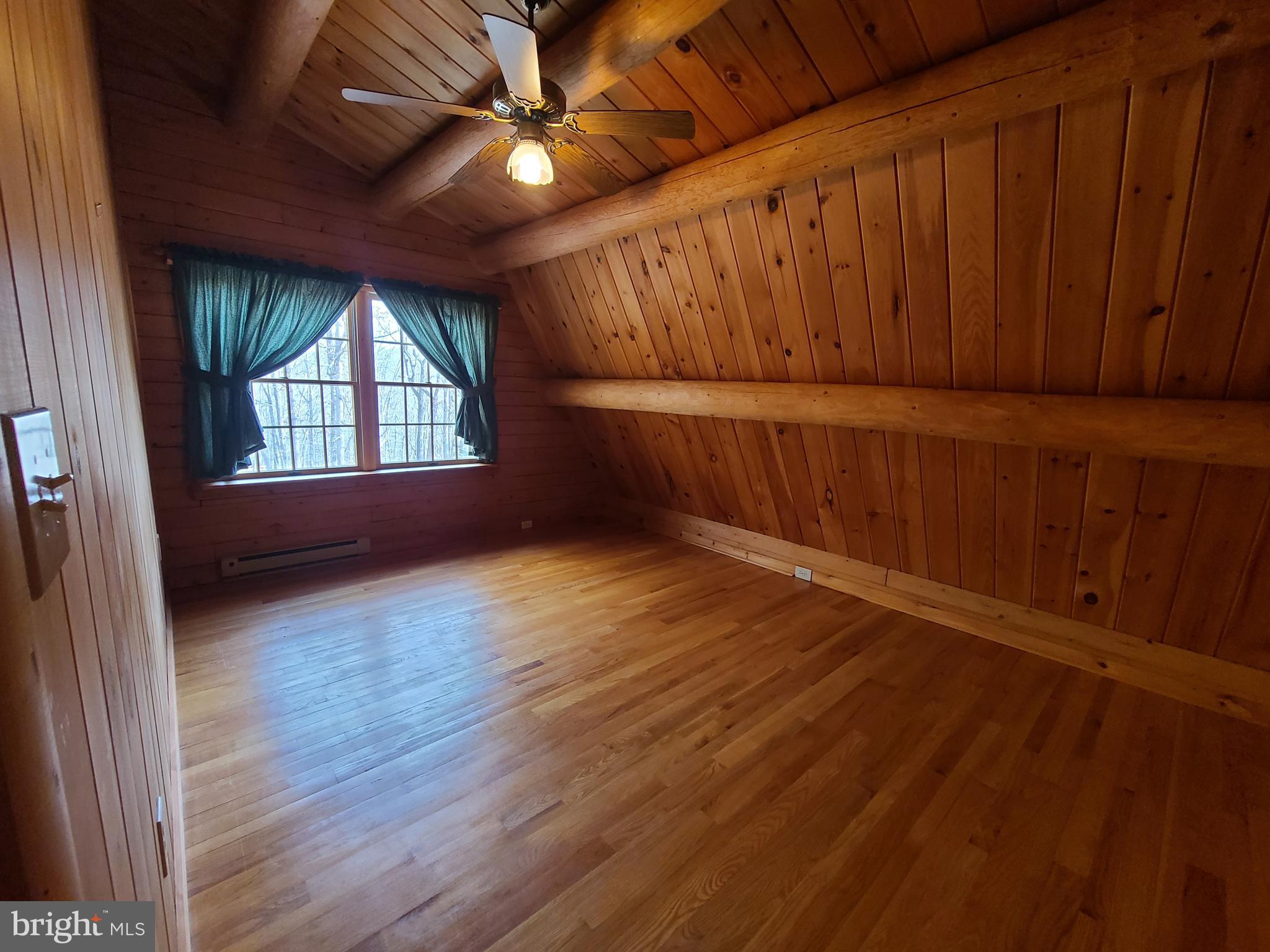 1537 Hidden Valley Road Franklin, WV 26807 - Photo 39 of 78 an empty room with wooden floor and windows