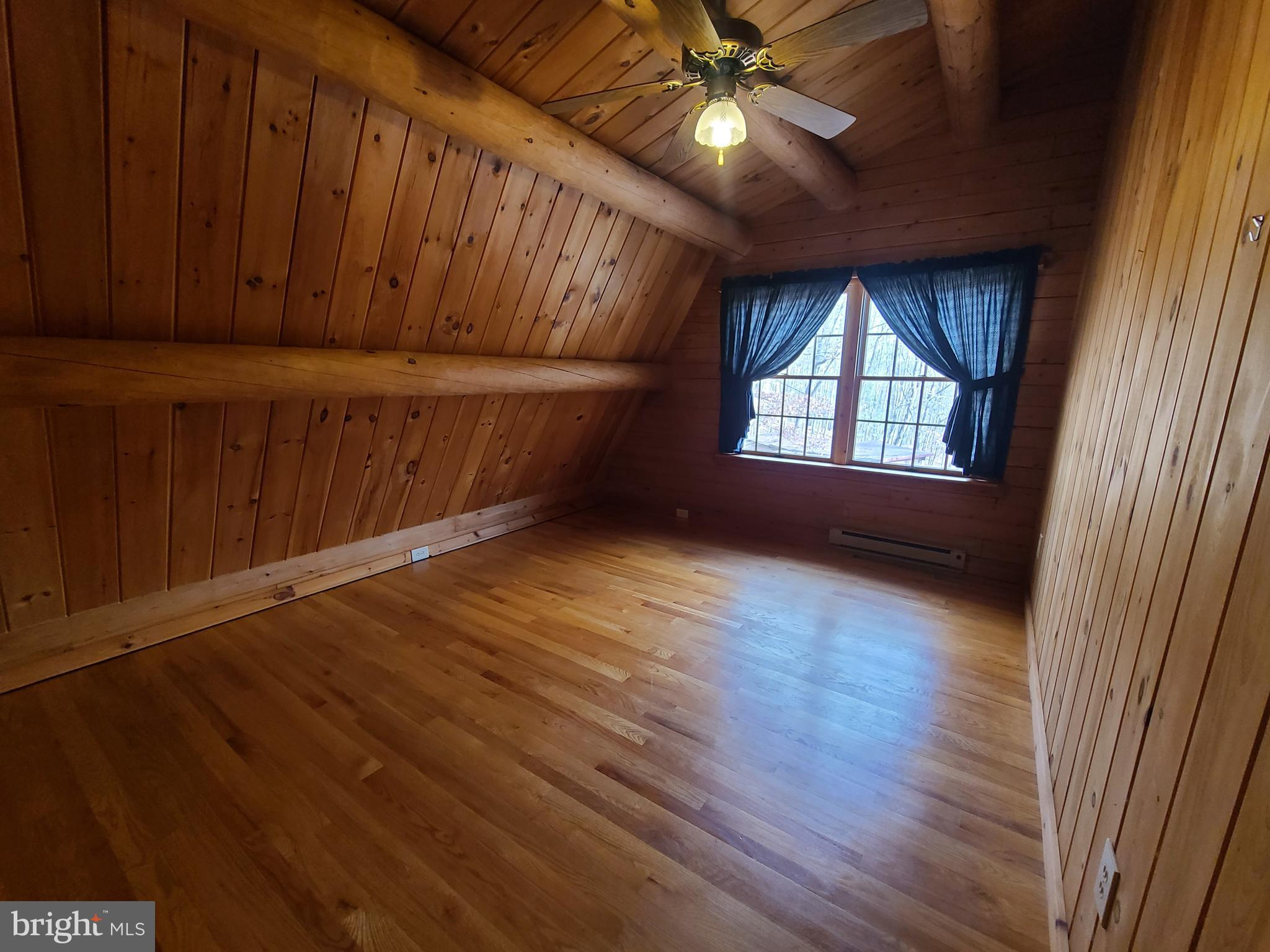 1537 Hidden Valley Road Franklin, WV 26807 - Photo 43 of 78 an empty room with wooden floor fan and windows