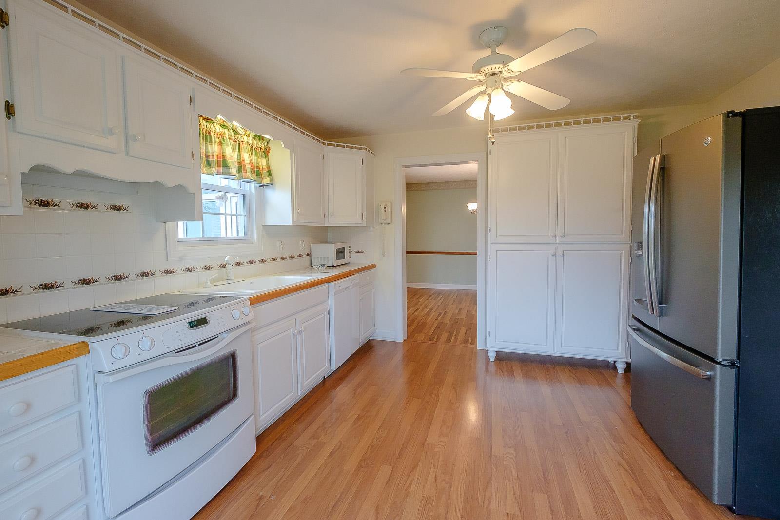 900 Red Boiling Springs Road Lafayette, TN 37083 - Photo 14 of 30 a kitchen with stainless steel appliances granite countertop a sink a stove a refrigerator cabinets and wooden floor