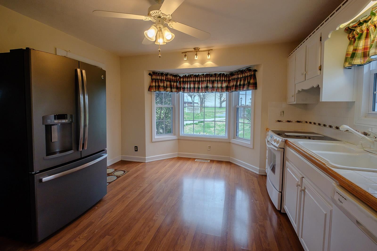 900 Red Boiling Springs Road Lafayette, TN 37083 - Photo 15 of 30 a kitchen with stainless steel appliances granite countertop a refrigerator a sink dishwasher a stove and white countertops with wooden floor