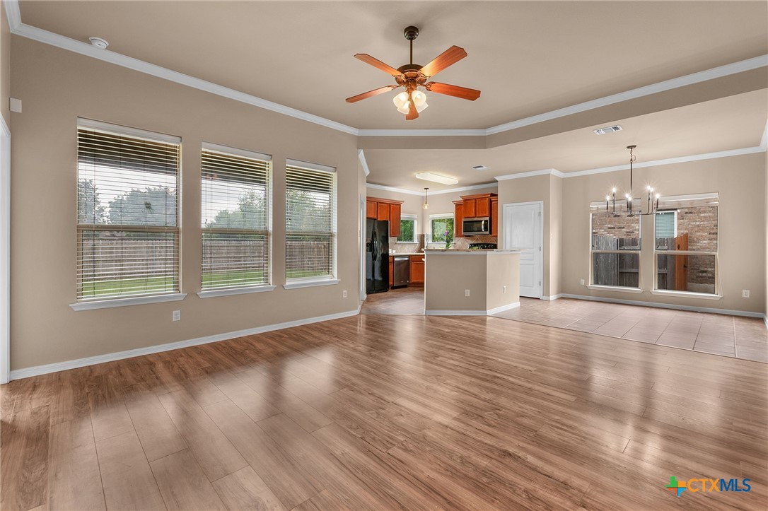 408 Copper Ridge Loop Temple, TX 76502 - Photo 13 of 39 Living area featuring a tray ceiling, crown molding, and large windows for natural light