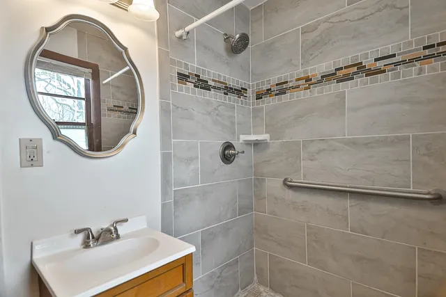 a bathroom with a sink a shower and a mirror