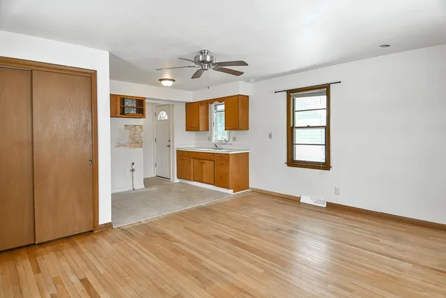 a view of a room with wooden floor and a ceiling fan