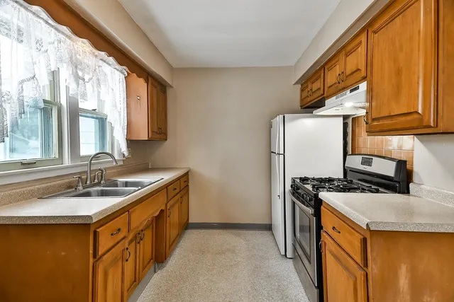 a kitchen with stainless steel appliances granite countertop a sink stove and refrigerator