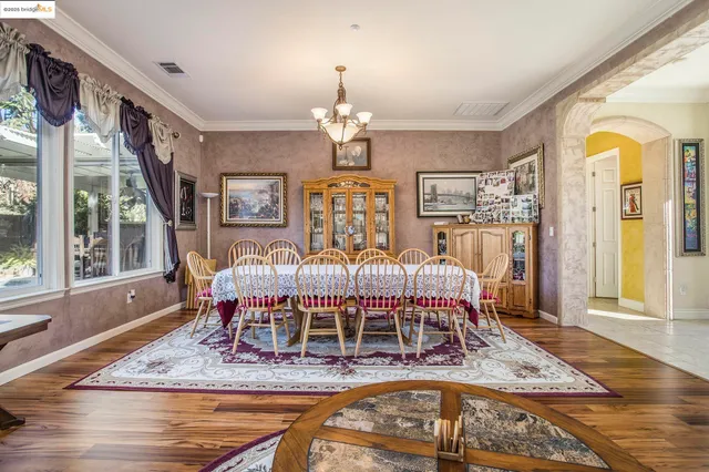 a living room with furniture dining table a flat screen tv and a large window