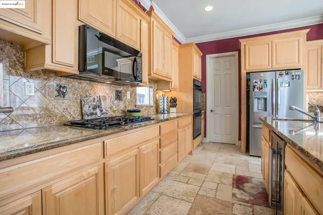 a kitchen with stainless steel appliances granite countertop a stove a sink and a microwave
