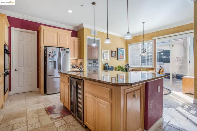 a kitchen with stainless steel appliances granite countertop a stove a refrigerator and a wooden cabinets