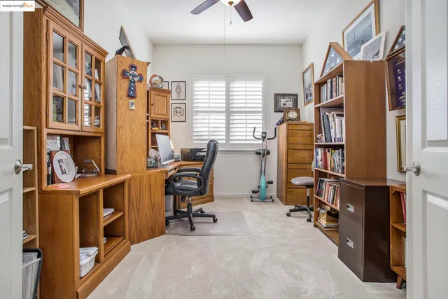 a view of a workspace with furniture and a window