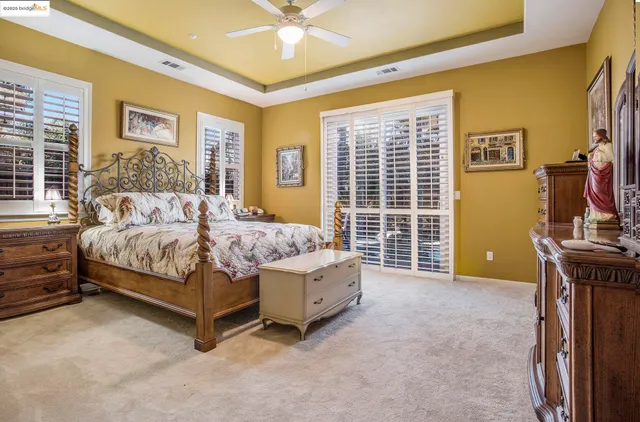 a bedroom with a bed and a flat tv screen on dresser
