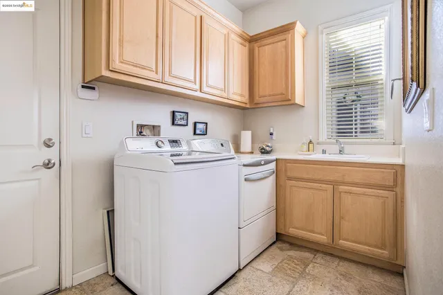 a utility room with sink dryer and washer