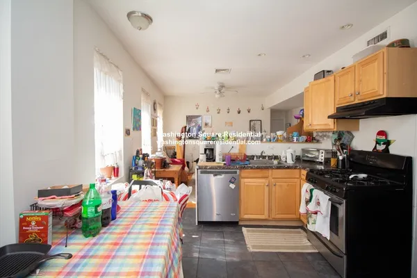 a kitchen filled with a white cabinets stove and wooden floor