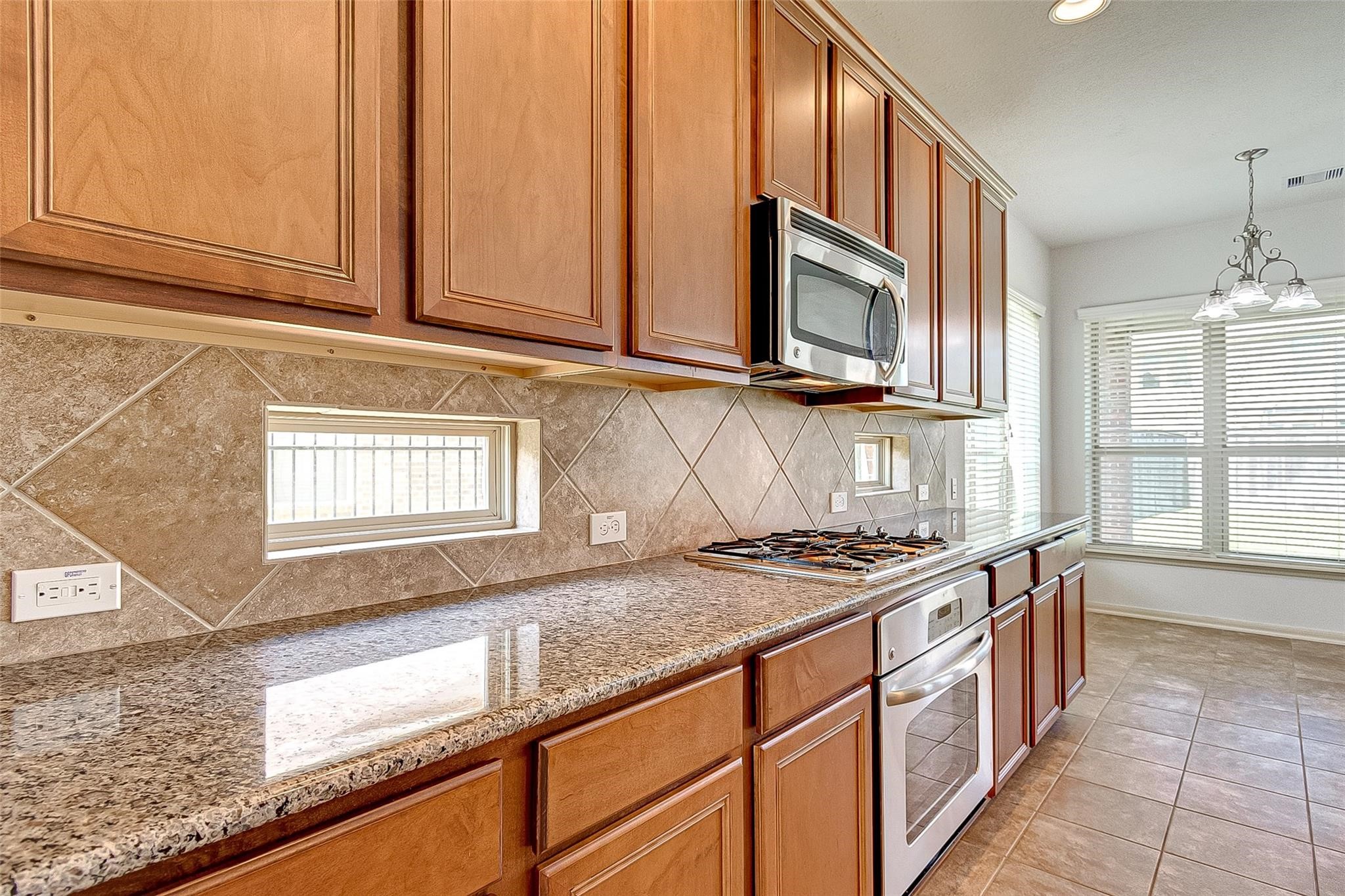 79 West Lasting Spring Circle Spring, TX 77389 - Photo 25 of 48 a kitchen with stainless steel appliances granite countertop a stove a sink and a microwave