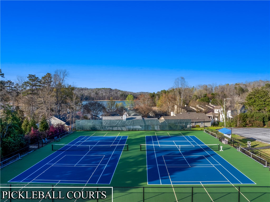 139 Tulip Lane Westminster, SC 29693 - Photo 33 of 37 Sporting fun awaits on these dual pickleball courts, set against a backdrop of tranquil waters and distant wooded hills.