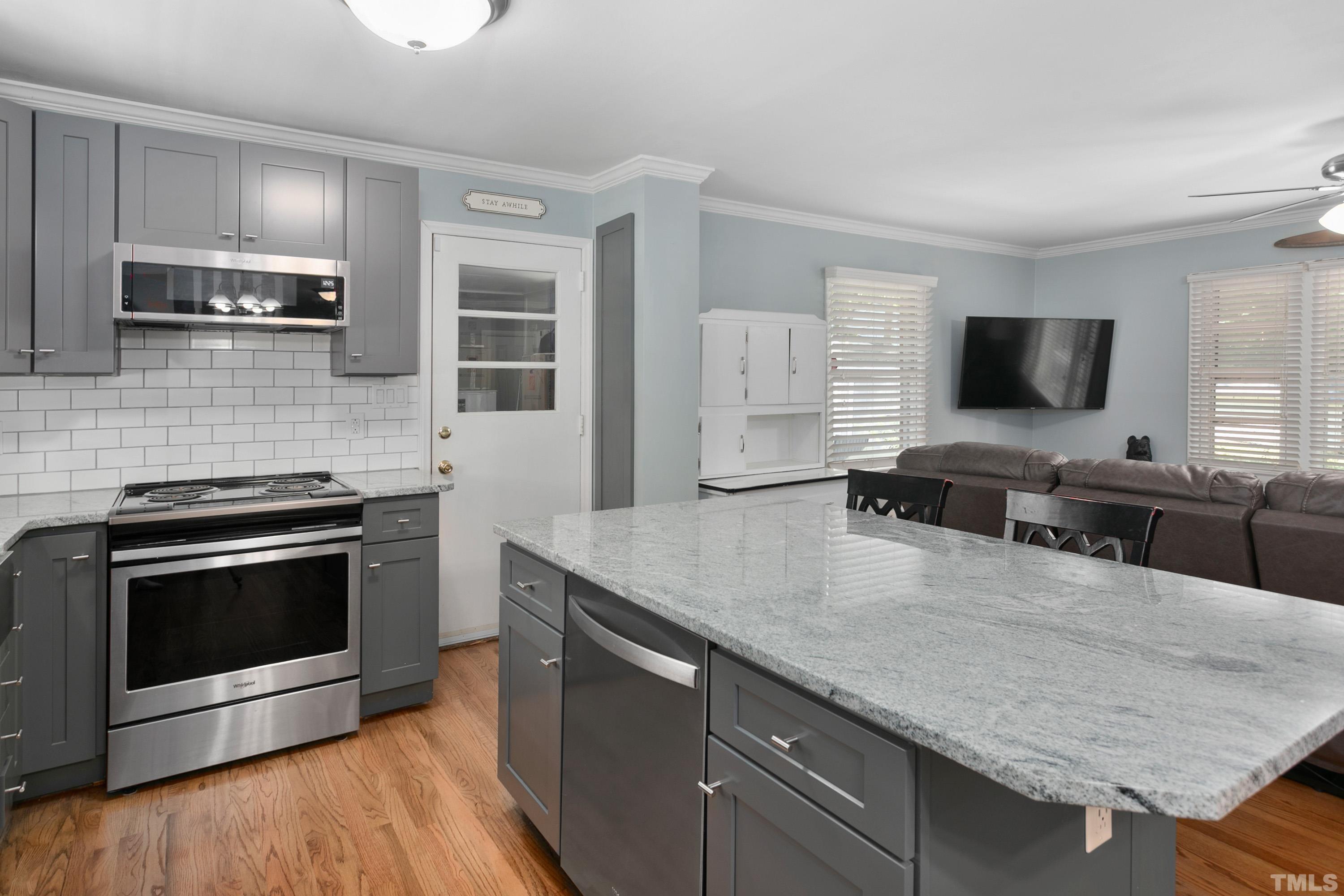 3702 Randell Road Garner, NC 27529 - Photo 9 of 24 a kitchen with stainless steel appliances a stove microwave and sink
