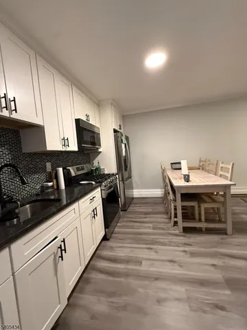 a kitchen with appliances a sink and cabinets