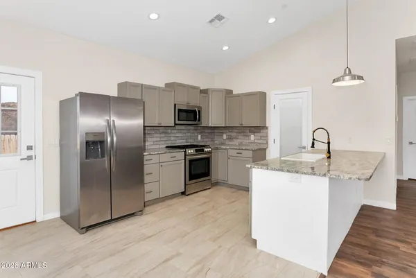 a kitchen with a sink stainless steel appliances and white cabinets