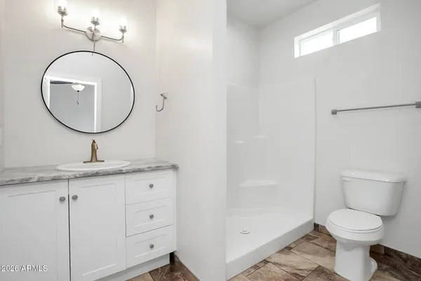 a bathroom with a granite countertop toilet a sink and a mirror