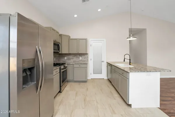 a kitchen with a sink refrigerator and microwave