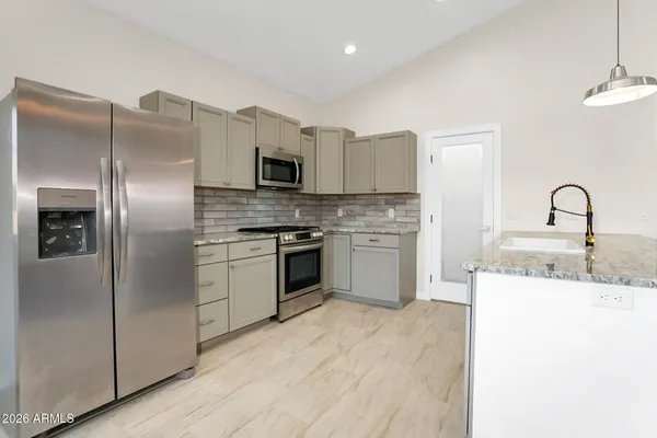 a kitchen with a sink stainless steel appliances and white cabinets