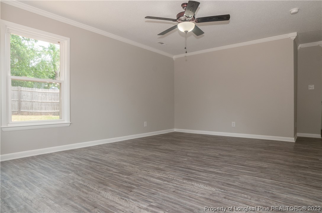3313 Red Fox Road Spring Lake, NC 28390 - Photo 8 of 33 an empty room with wooden floor fan and windows