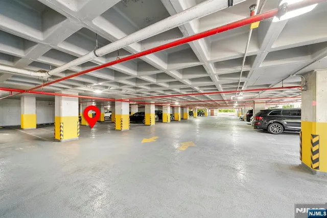 a front view of a building with garden and trees
