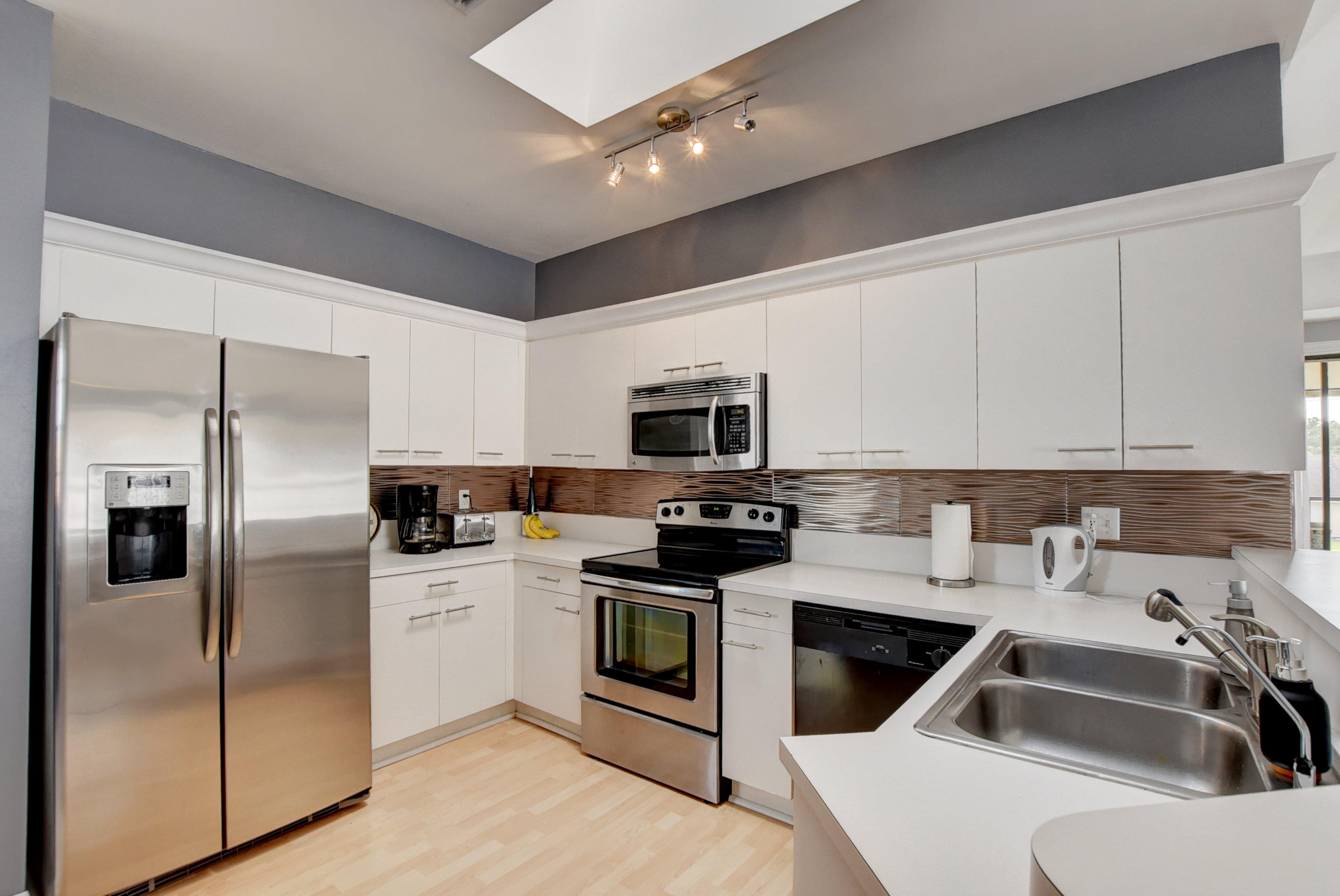 8682 Vía Reale, Unit 4 Boca Raton, FL 33496 - Photo 21 of 51 a kitchen with a sink a stove and refrigerator