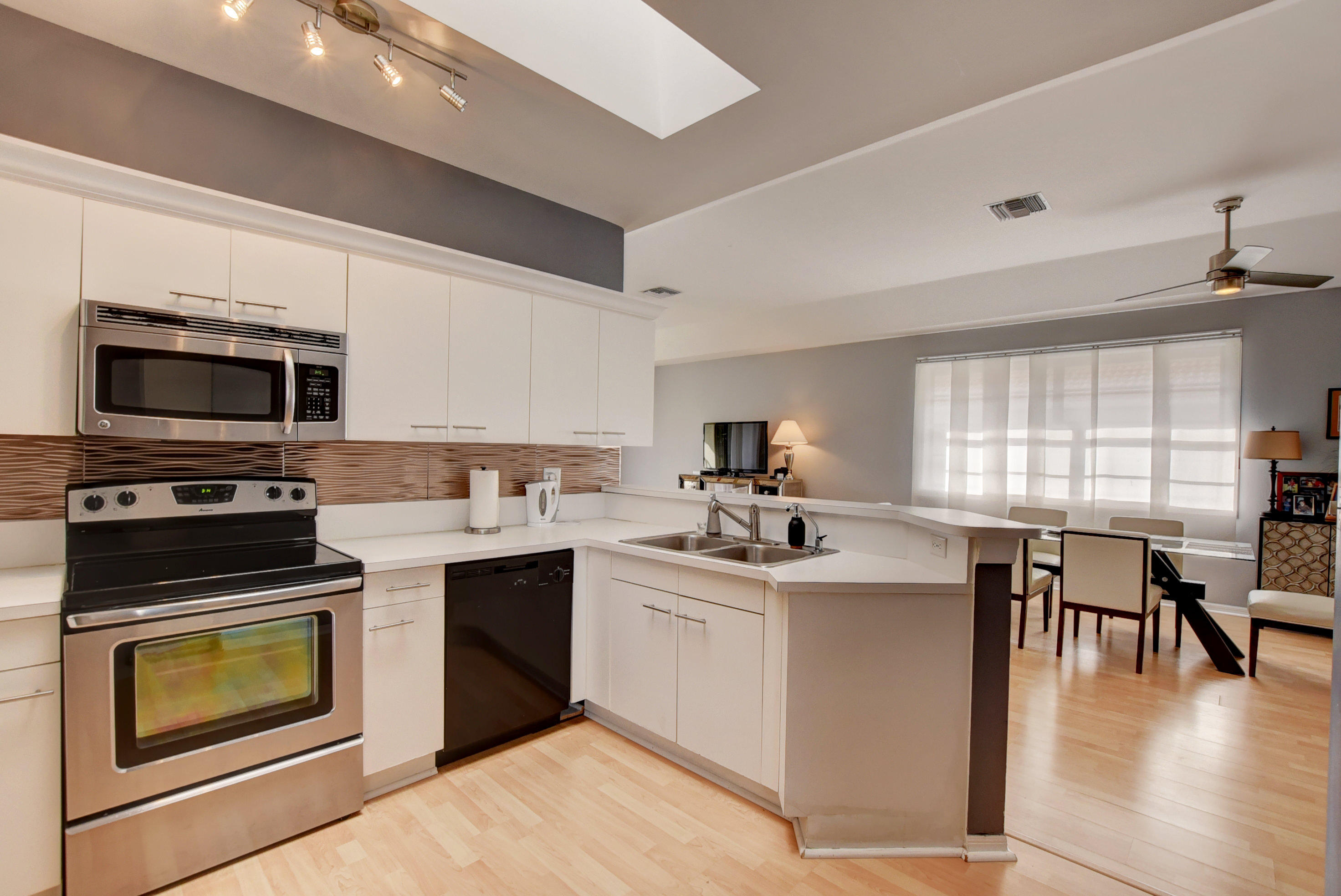 8682 Vía Reale, Unit 4 Boca Raton, FL 33496 - Photo 22 of 51 a kitchen with a sink stove and microwave