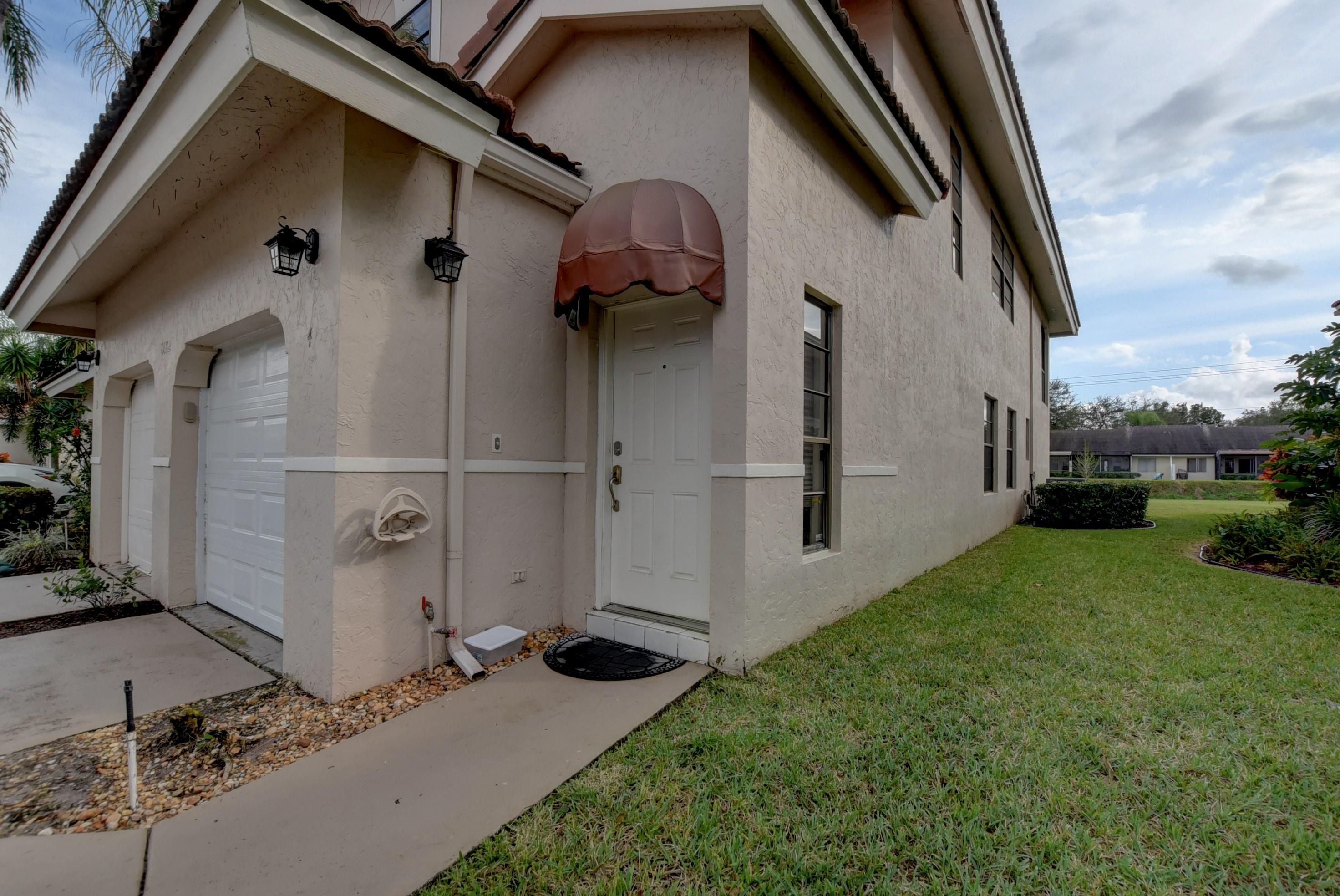 8682 Vía Reale, Unit 4 Boca Raton, FL 33496 - Photo 3 of 51 a backyard of a house with wooden floor and fence
