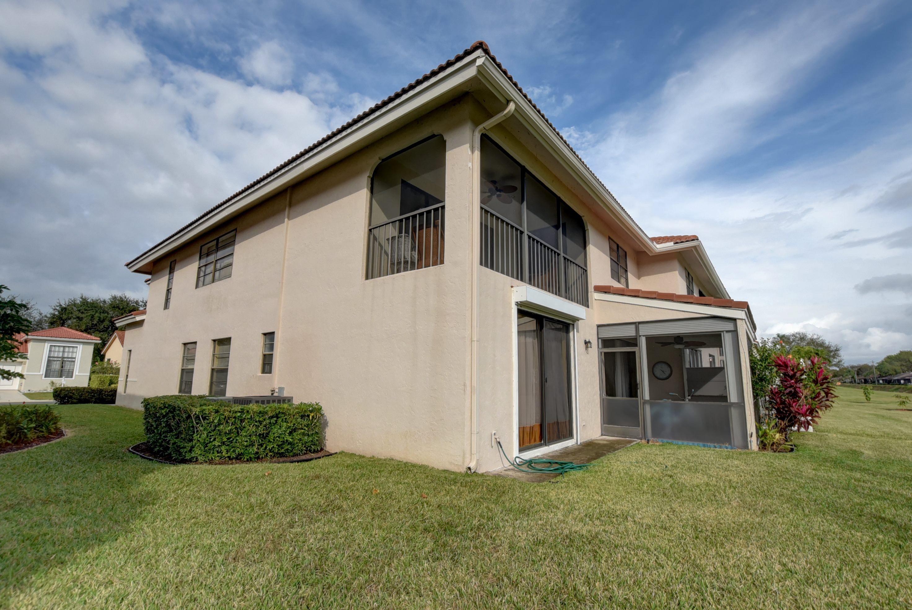 8682 Vía Reale, Unit 4 Boca Raton, FL 33496 - Photo 33 of 51 a front view of a house with a yard
