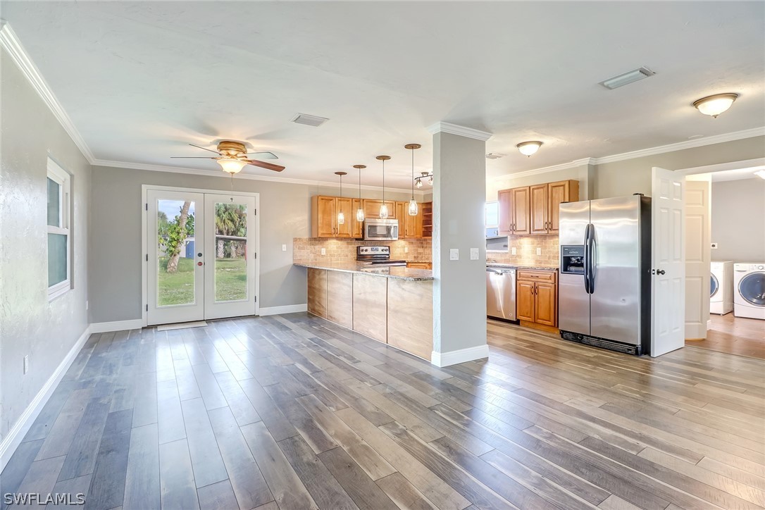 5381 Jackson Road Fort Myers, FL 33905 - Photo 1 of 23 a kitchen with stainless steel appliances wooden floor and large windows