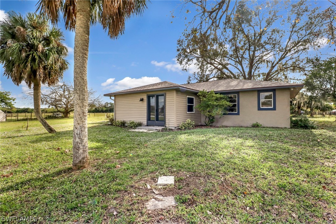 5381 Jackson Road Fort Myers, FL 33905 - Photo 3 of 23 a backyard of a house with table and chairs under an umbrella