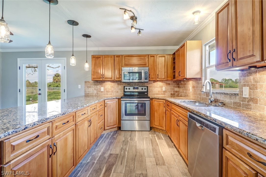 5381 Jackson Road Fort Myers, FL 33905 - Photo 5 of 23 a kitchen with stainless steel appliances kitchen island granite countertop a stove a sink and a granite counter tops with wooden floors
