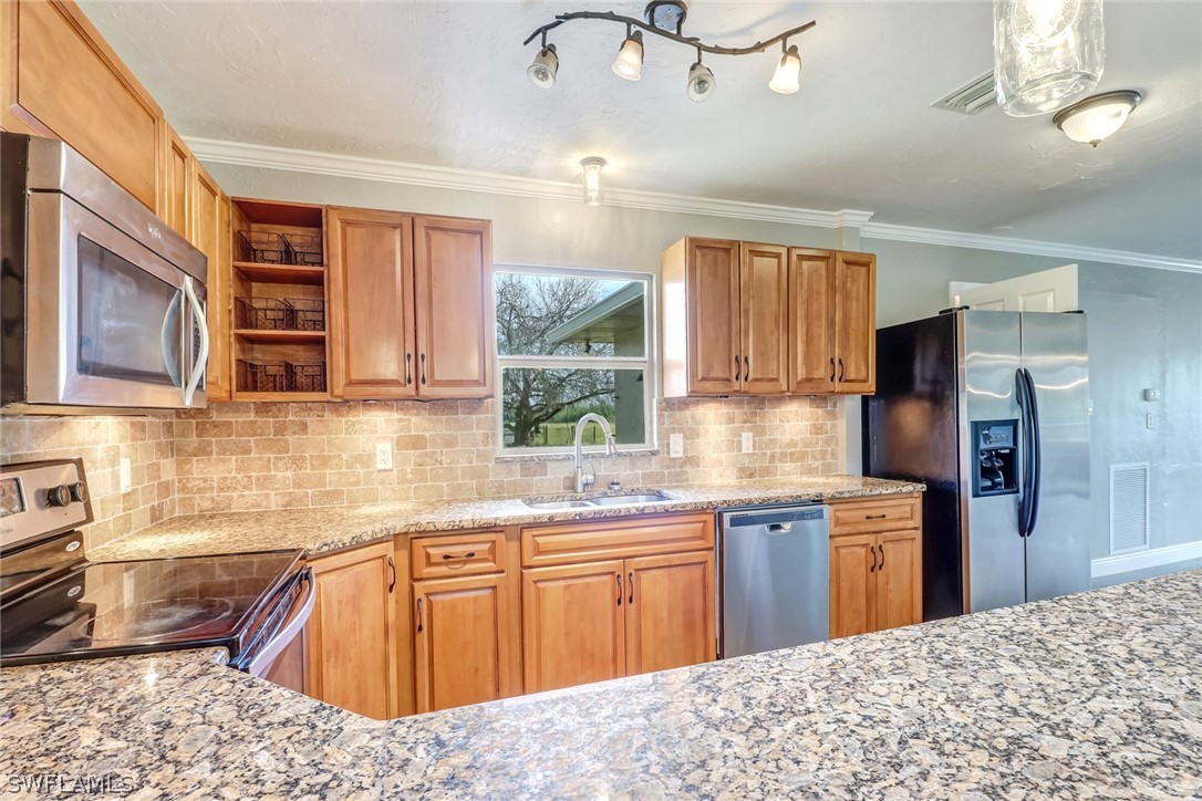 5381 Jackson Road Fort Myers, FL 33905 - Photo 6 of 23 a kitchen with stainless steel appliances kitchen island granite countertop a sink dishwasher stove and refrigerator