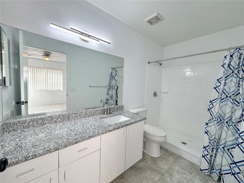 292 Winter Ridge Boulevard, Unit 292 Winter Haven, FL 33881 - Photo 13 of 37 a bathroom with a granite countertop sink a toilet and shower