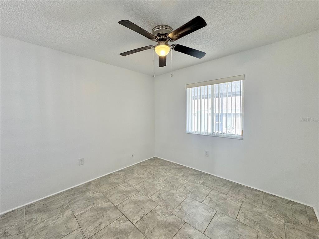 292 Winter Ridge Boulevard, Unit 292 Winter Haven, FL 33881 - Photo 14 of 37 an empty room with ceiling fan and window