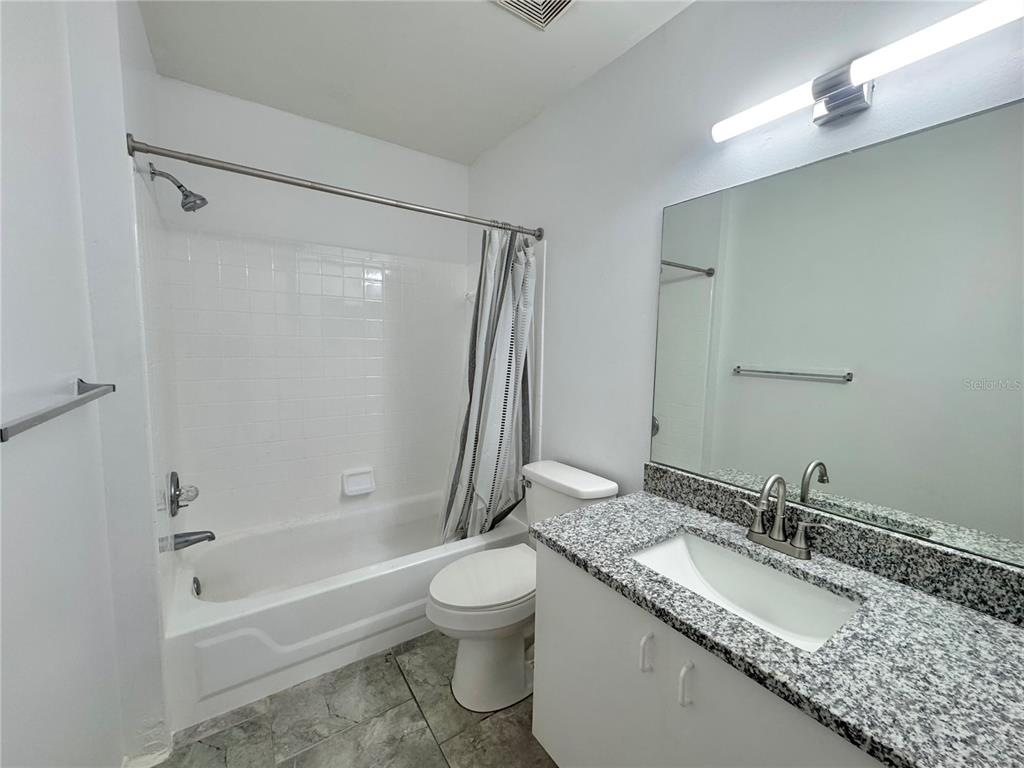 292 Winter Ridge Boulevard, Unit 292 Winter Haven, FL 33881 - Photo 17 of 37 a bathroom with a granite countertop sink toilet and shower