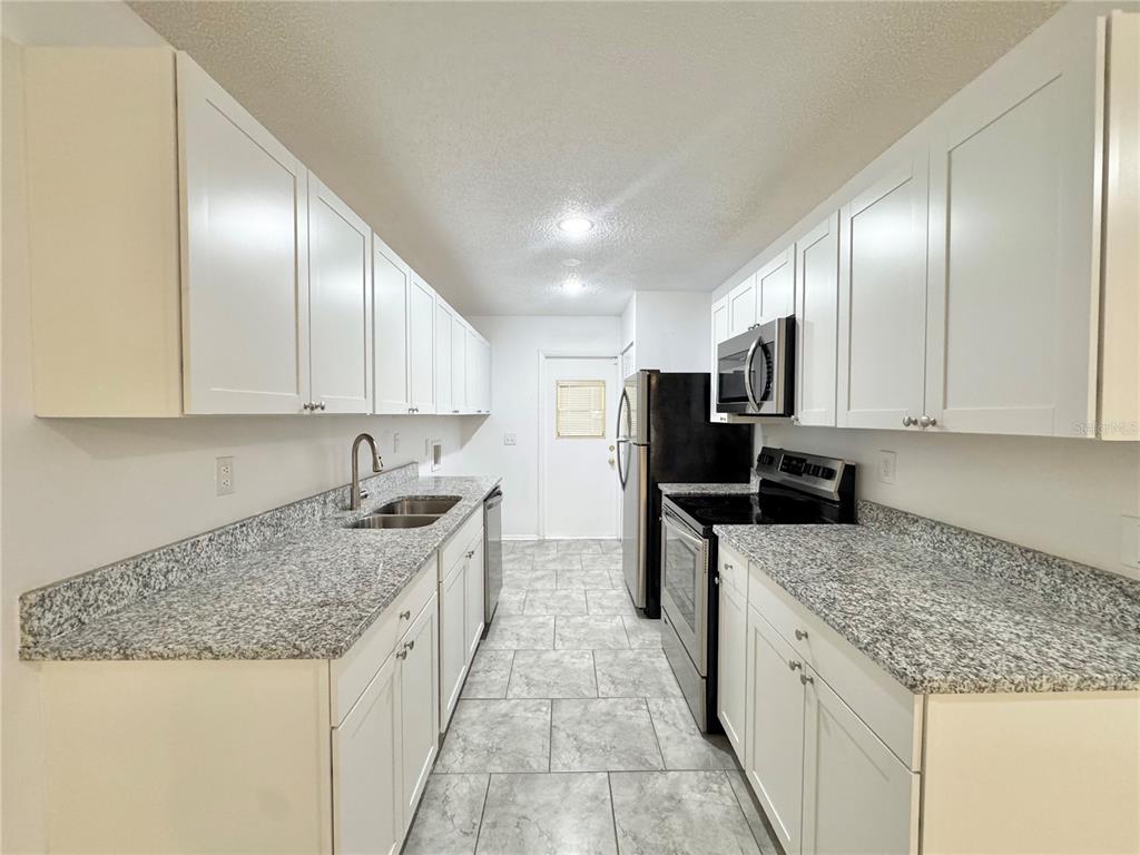 292 Winter Ridge Boulevard, Unit 292 Winter Haven, FL 33881 - Photo 5 of 37 a kitchen with stainless steel appliances granite countertop a sink stove and cabinets